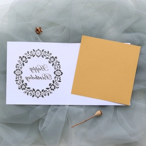 Macro shot of laser-cut floral patterns and Happy Birthday lettering on elegant paper cards