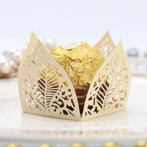Macro detail of laser-cut leaf-shaped paper wrappers for spherical chocolate truffles
