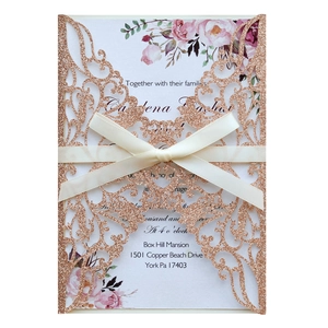 Détail d'invitation rose doré pailleté découpé au laser avec fleurs et nœud en satin