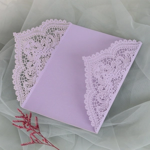Detail der fliederfarbenen Hochzeitseinladung mit Laserschnitt auf grauem Tüll