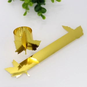 Close-up of golden maple leaf napkin rings showing flat and assembled round shapes