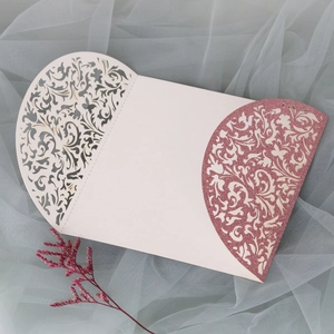 Détail d'un faire-part de mariage découpé au laser avec motifs de vigne pailletés roses