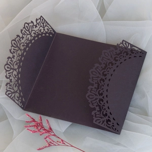 Detalles de patrones calados con láser en sobres de invitaciones de boda marrones