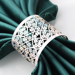 Macro shot of silver hollow floral napkin ring with intricate laser cut patterns