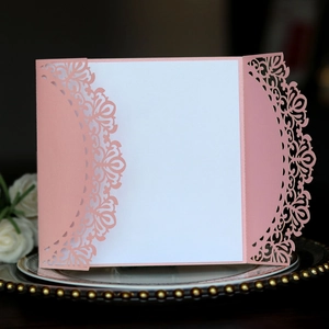 Detalle de corte láser floral en elegante papel perlado rosa para invitación de boda
