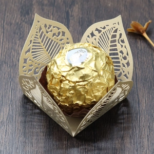 Macro shot of laser-cut gold pearlescent paper candy box with intricate leaf patterns