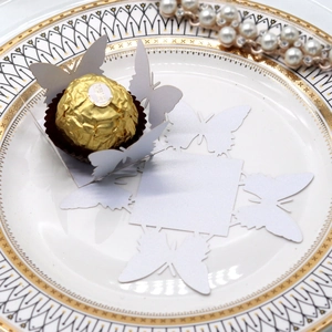 Laser cut pearl white butterfly chocolate holder on elegant porcelain plate
