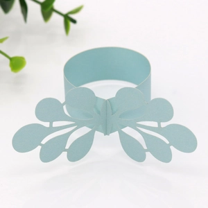 Detail of laser-cut light blue paper napkin ring with elegant floral lace butterfly pattern