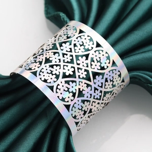 Macro shot of silver hollowed lace floral pattern on a polished metal napkin ring