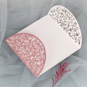 Détails macro des motifs floraux découpés au laser et paillettes roses sur cartes de mariage