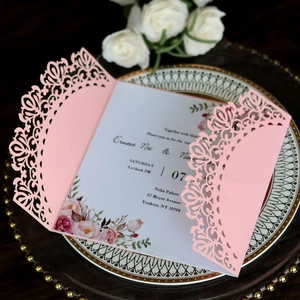 Detalle de invitación de boda rosa cortada con láser y patrones florales calados