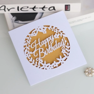 Detail of laser-cut Happy Birthday card with elegant floral hollow design and gold lining