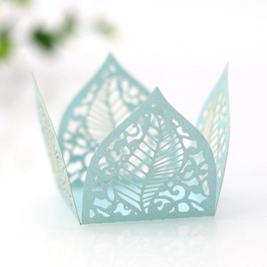 Macro shot of light blue laser-cut paper cupcake liner with intricate leaf pattern