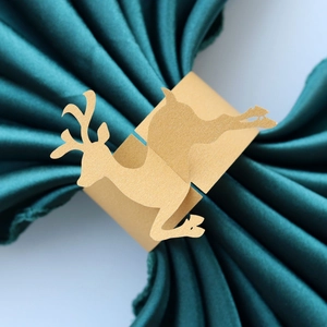 Detail of laser-cut golden reindeer napkin ring on a teal satin fabric napkin decoration