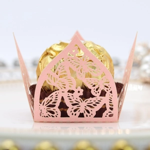 Makroaufnahme von rosa lasergeschnittenem Schmetterling-Schokoladenhalter mit Goldfolie