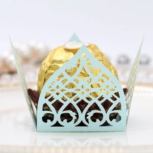 Detail view of light blue laser cut cupcake wrapper with elegant lace pattern
