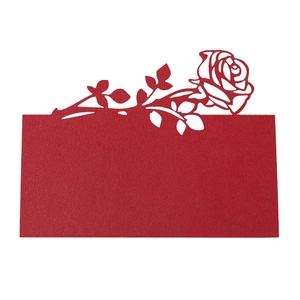 Detail of laser-cut red rose place card featuring intricate hollow floral patterns