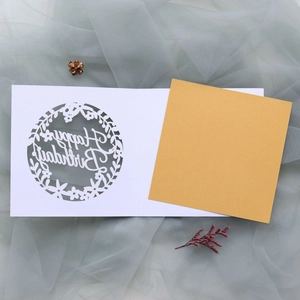 Macro shot of laser-cut Happy Birthday card with elegant gold liner and floral wreath