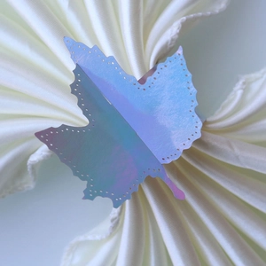 Detail of laser-cut maple leaf napkin ring with iridescent holographic finish and hollow dots