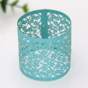 Detailed macro view of laser-cut light blue floral lace pattern on paper napkin ring