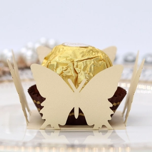 Laser-cut butterfly paper chocolate holder in beige with a golden wrapped truffle inside