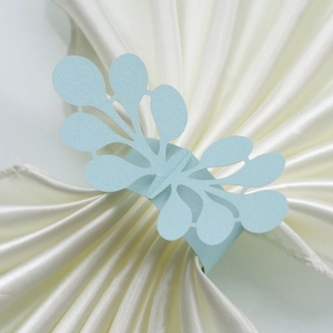 Detailed laser-cut light blue pearlized paper napkin ring with intricate leaf pattern