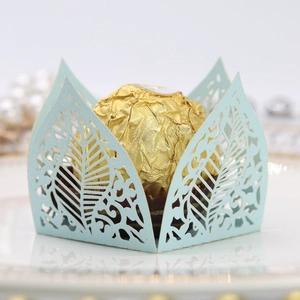 Detailed laser-cut leaf pattern on light blue favor box holding gold foil chocolate