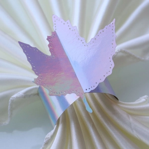 Detailed view of iridescent laser-cut maple leaf paper napkin ring for table decor