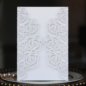 Detailed laser-cut white rose pattern on a premium wedding invitation sleeve