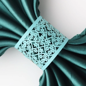 Macro shot of light blue laser-cut napkin rings with intricate floral lace patterns
