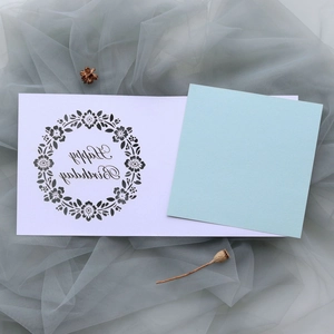 Detail of laser-cut floral wreath and Happy Birthday text on light blue greeting card