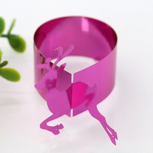 Macro shot of rose red metallic reindeer paper napkin ring for festive table decor