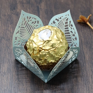 Detail of laser-cut light green paper leaf tray with fine cutout patterns for chocolates