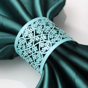 Macro view of light blue pearlescent paper napkin ring with laser-cut floral patterns