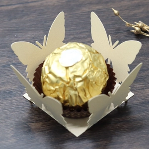 Detailed laser-cut butterfly candy box holder in beige cardstock with golden chocolate