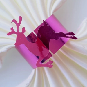 Close-up of a glossy pink reindeer paper napkin ring for Christmas table decor