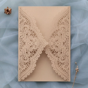 Detail of laser-cut lace floral pattern on champagne wedding invitation envelope