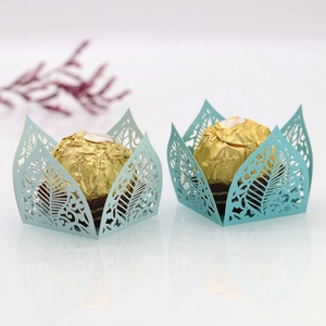 Detail of laser-cut leaf pattern on mint green hollow candy box with golden chocolate