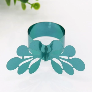 Macro shot of teal green metallic napkin ring with intricate hollow leaf design