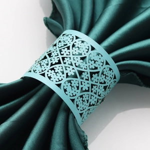 Macro view of light blue laser-cut pearlescent paper napkin rings with floral lace patterns