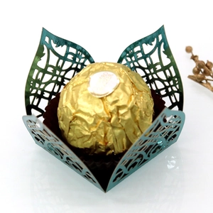 Macro view of laser-cut petal design on dark green metallic paper chocolate box