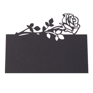 Macro view of laser-cut hollow rose pattern on elegant black cardstock table tent