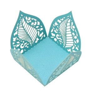 Macro detail of laser-cut blue pearlescent paper candy box with hollow leaf patterns