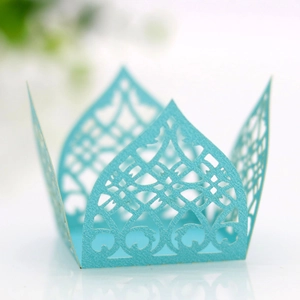 Detail view of light blue laser-cut cupcake wrappers with intricate hollow patterns
