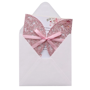 Détail d'une invitation de mariage papillon découpée au laser rose avec ruban de soie