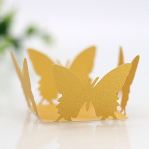 Detail of laser-cut golden butterfly paper wrappers for cupcakes and party favors