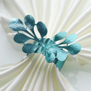 Elegant blue leaf shaped napkin ring with hollow design on white silk background