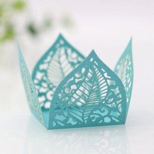 Detail of laser-cut sky blue paper candy box with intricate leaf patterns and floral lace