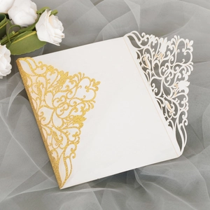 Détail du motif découpé au laser sur invitation blanche avec revêtement doré pailleté