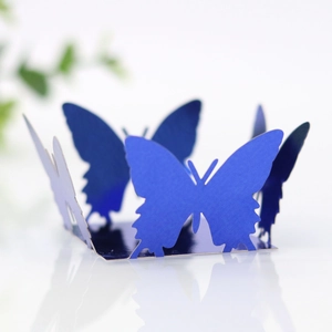 Detail of laser-cut hollow butterfly cake wrapper in dark blue for party table decor